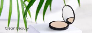 Pressed beige powder by Radical Cosmetics, set in a natural landscape with green leaves and a white background. Luxury, clean beauty product perfect for private label cosmetics and white label manufacturers. Made with organic, vegan, and cruelty-free ingredients, ideal for contract manufacturing.