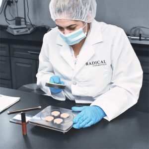 Lab technician in a white coat inspecting cosmetic product during research and development for Radical Cosmetics, a luxury private label and white label manufacturer specializing in high-quality, custom beauty products.