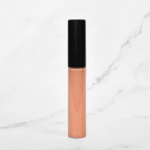 New nude lip gloss by Radical Cosmetics – warm nude shade with golden shimmer, enhanced formula for fuller-looking lips and high-shine finish, clean beauty and USA-made.
