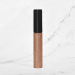 Photo of Radical Cosmetics' Primrose Lip Gloss, a soft rosy pink shade with warm undertones and a delicate, dewy finish. This elegant lip gloss delivers a subtle flush of color, blending notes of blush rose and petal pink with a hint of sheer shimmer for a natural, luminous look. The formula is ultra-hydrating, non-sticky, and enriched with clean, skin-loving ingredients. Housed in a clear, minimalist tube that showcases the gentle pink hue. Keywords: primrose lip gloss, rosy pink lip gloss, natural lip gloss, clean beauty lip products, vegan lip gloss, cruelty-free cosmetics, paraben-free lip gloss, hydrating lip color, soft glam lip gloss, blush pink lip gloss, private label lip products, natural makeup essentials, lip gloss for warm undertones, eco-conscious beauty, USA-made cosmetics, Radical Cosmetics lip collection, sheer pink gloss, trending nude lip shades, glossy finish lip gloss.